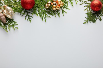 Wall Mural - top view of shiny golden and red christmas decoration on green thuja branches isolated on white