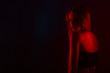 © primipil - Young beautiful woman in lingerie posing in red back light