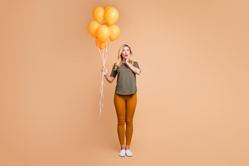 Poster - Full body photo of amazing charming blond lady emotional surprise holding bright orange balloons came birthday party wear green t-shirt trousers isolated beige color background