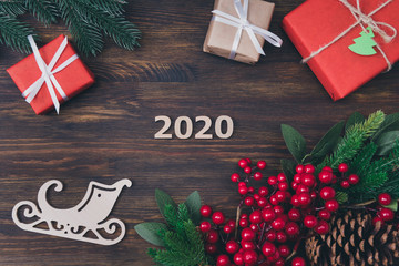Wall Mural - 2020 is coming. Top above high angle view photo of 2020 numbers small and big giftboxes with white ribbon pine cones with red berries on darn wooden background