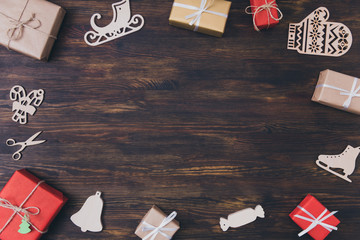 Wall Mural - Top above high angle view photo of christmas time decor composition of x-mas decor giftboxes wooden ice skates gloves sledges candy canes lay on brown table making place for text newyear