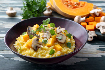 Wall Mural - risotto con zucca gialla e funghi su tavolo di cucina rustico verde