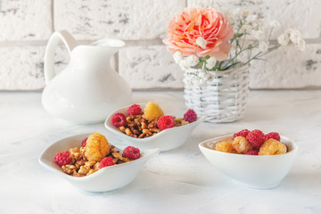 Healthy and healthy Breakfast of muesli and fresh raspberries and strawberries with yogurt on a light background. Copy space