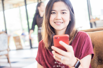 Wall Mural - Business women hand use smartphone while sitting in cafe