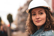 © cineberg - Close-up portrait of a pretty and young female factory worker wearing a white protective helmet