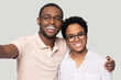 © fizkes - Head shot happy African American couple in glasses taking selfie