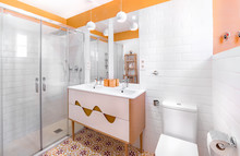 Young And Trendy Interior Design. Modern And Colorful Bathroom With Wooden Cabinet.  Yellow And Orange Tiles.