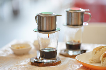 Drip coffee.  Breakfast set menu with Vietnamese dripping coffee served with buns. Soft focus.