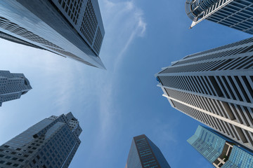 Business buildings skyline looking up with blue sky background. High-rise skyscraper, modern architecture.