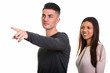 © Ranta Images - Studio shot of young couple with man pointing finger and happy w