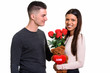 © Ranta Images - Young happy couple smiling and in love with woman holding red ro