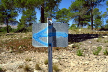 Sticker - Panneau en fer avec flèche bleue peinte dirigée vers la gauche.