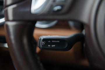 Wall Mural - The interior of the car with a view of the steering wheel, dashboard, seats and cruise control with light brown leather trim