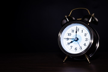 The clock on the table has a black background