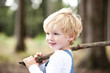 © Michelle Fraikin/Westend61 - Portrait of smiling little boy with branch