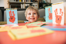 Happy Little Boy With Self-made Easter Cards At Home