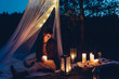 © Jana Manz/Westend61 - Happy woman in a romantic camp in autumnal nature by candle light