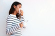 © Cavan Images - Young woman blowing nose into tissue