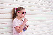 Young Girl Wearing Pink Sunglasses Drinking Milk Through A Straw