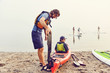 © Cavan Images - Instructor helps his young student get ready for a kayaking trip