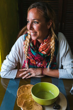 Female With Portion Of Mexican Guacamole Seated At Cafe Table Smiling