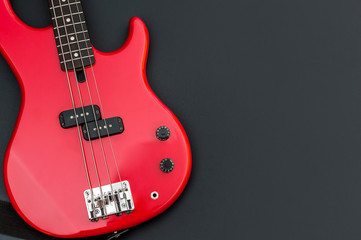 Wall Mural - Red electric bass guitar on black. Space for text.