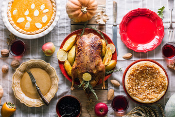 Wall Mural - Thanksgiving dinner table with turkey, pumpkin and apple pie, top view