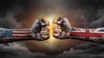 USA vs UK. Fists with flags. Battle of two countries on sky.