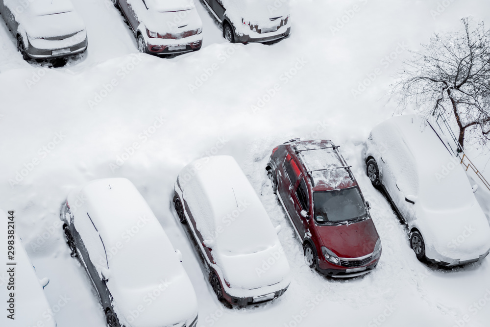 Parked cars and the road are covered with smooth layer of snow but one ...