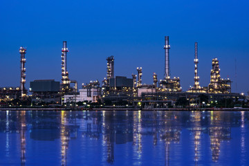 Oil and gas refinery plant area near the river at twilight, sunset time