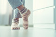 Leinwandbild Motiv Woman in pajamas and cozy soft warm knitted winter socks at home