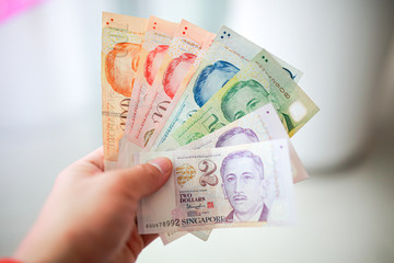 Hand hold a singapore dollar banknote ready for shopping, Singapore currency many value in shopping.