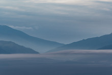 Gentle Hills In Bluish Haze. Soft Light In Early Morning, Silhouettes Of Mountains