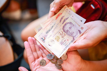 Hand hold a singapore dollar banknote ready for shopping, Singapore currency many value in shopping.