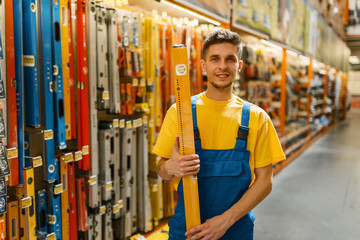 Wall Mural - Male builder with building level in hardware store