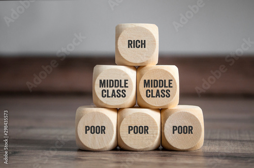 Cuadros en Lienzo Pyramid made of cubes and dice with rich, middle class and poor on wooden backgr