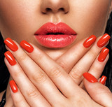 Closeup sexy female lips with red lipstick. Glamour fashion bright gloss make-up and manicure.