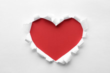 Torn Heart Shaped Hole In White Paper, Top View. Red Space For Text