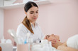 © Yakobchuk Olena - Professional masseuse massaging face of young woman