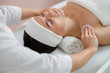 © Yakobchuk Olena - Beautician cleaning lady skin with cotton pads at spa salon