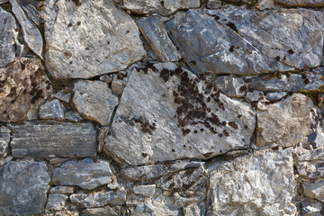 wall made of rocks. old grey stone wall on sunny day. natural background