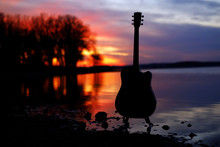 Guitar By The Lake At Sunset Time.