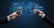 © ra2 studio - Close up of two hands holding smartphones to sync business data