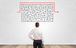 © ra2 studio - Businessman in doubt looking to a maze and searching the way out