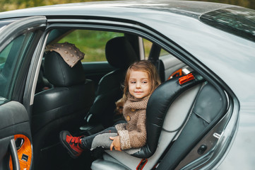 Three year old girl sitting in car seat.