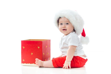 Wall Mural - Happy baby boy with a Santa hat with a Christmas present box