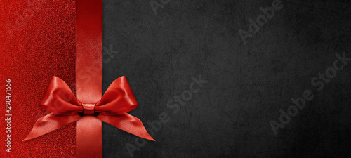 Fotografía gift card wishes merry christmas background with red ribbon bow on black shiny v