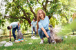 © Viktoriia - Volunteering. Young people volunteers outdoors girl close-up picking litter joyful