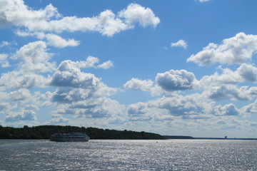 Wall Mural - Russian beautiful Volga river landscape, floating passenger cruise ship on water and blue sky with clouds background on Sunny summer day