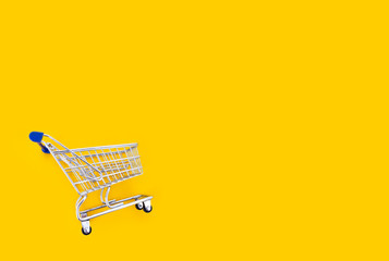 empty shopping cart over yellow background